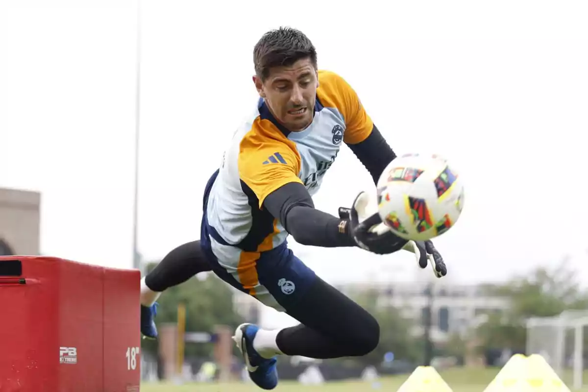 Portero de fútbol realizando una atajada durante un entrenamiento.