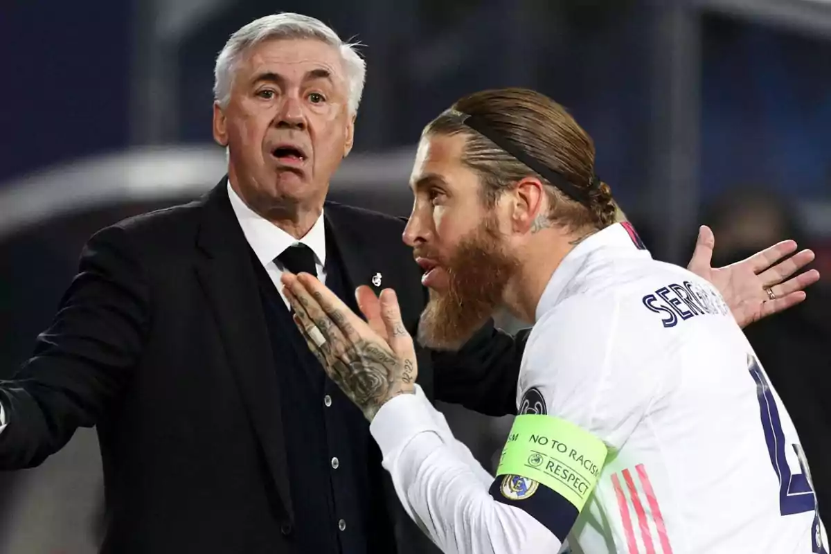 Un entrenador de fútbol y un jugador discutiendo en el campo durante un partido.