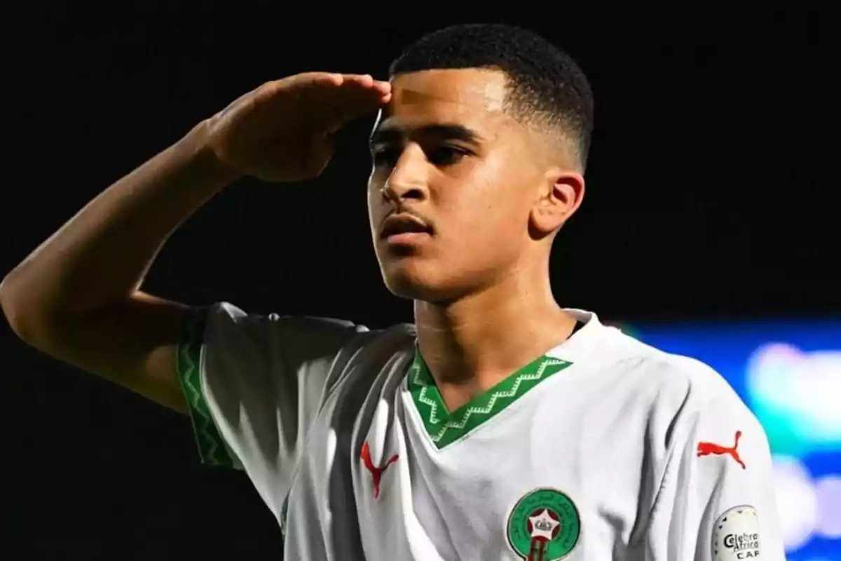 Joven futbolista con uniforme blanco de Marruecos haciendo un saludo militar Joven futbolista con uniforme blanco de Marruecos haciendo un saludo militar