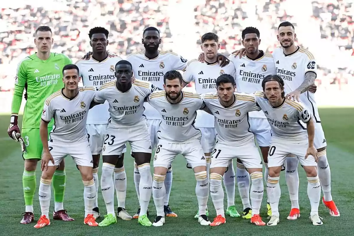 Jugadores de fútbol del Real Madrid posando para una foto de equipo en el campo antes de un partido.