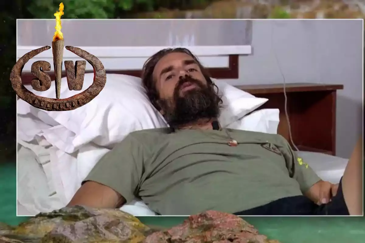 Hombre con barba recostado en una cama con almohadas, vistiendo camiseta verde y el logo de un reality de supervivencia en la esquina superior izquierda