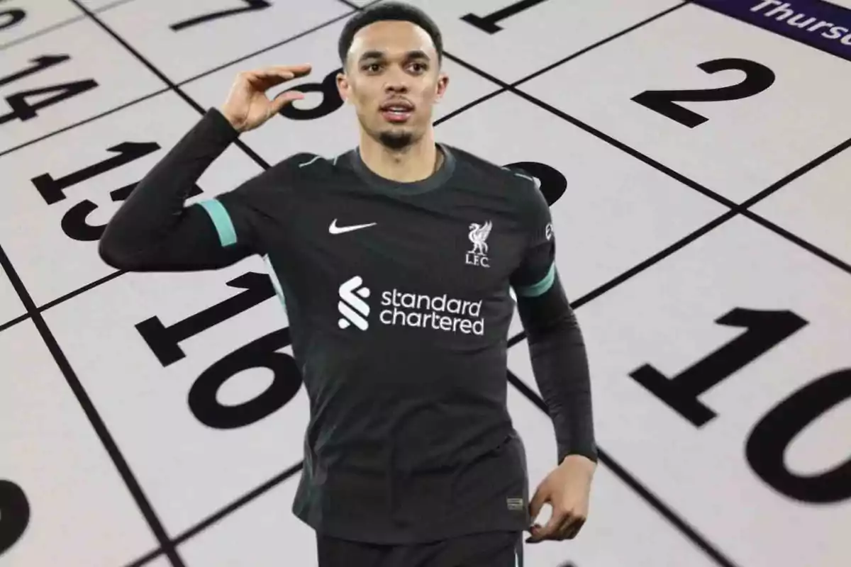 Jugador de fútbol con uniforme negro del Liverpool frente a un calendario.