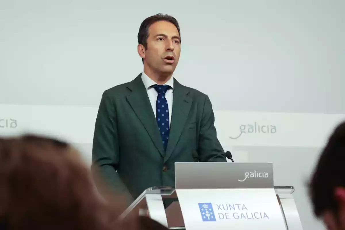 Hombre con traje hablando en un podio de la Xunta de Galicia durante una conferencia Hombre con traje hablando en un podio de la Xunta de Galicia durante una conferencia