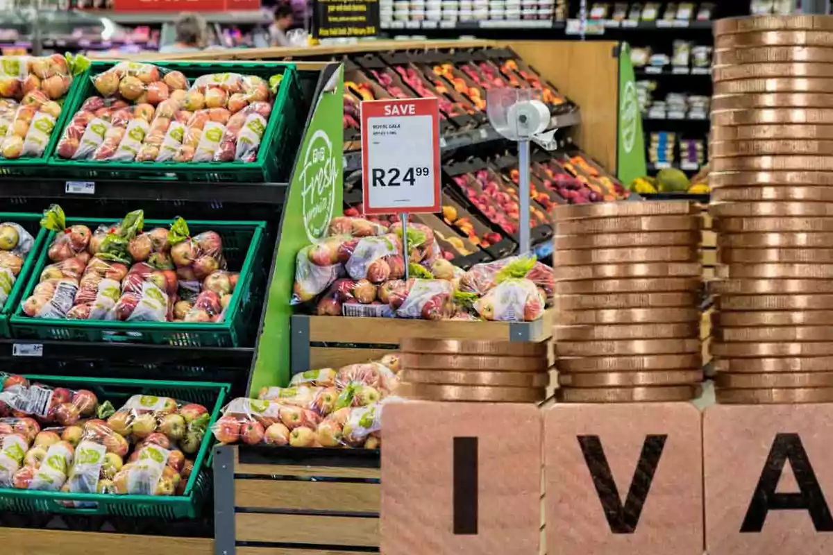 Frutas en un supermercado con un cartel de precio y monedas apiladas que forman la palabra IVA.