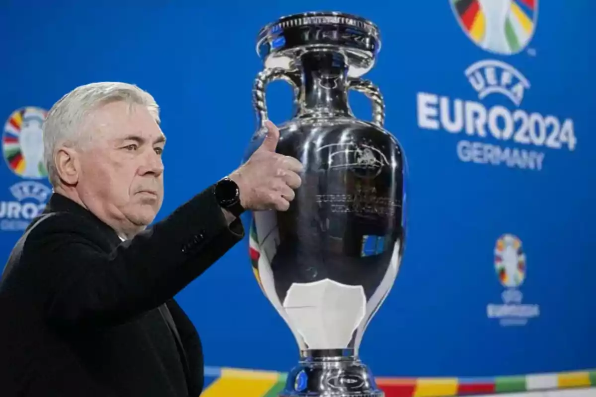 Carlo Ancelotti con el pulgar hacia arriba y la copa de la Eurocopa 2024 al lado