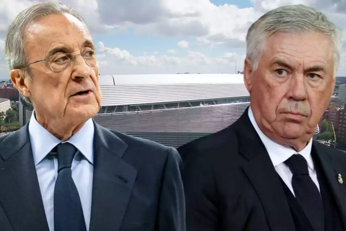 Dos hombres de traje frente a un estadio moderno bajo un cielo parcialmente nublado.