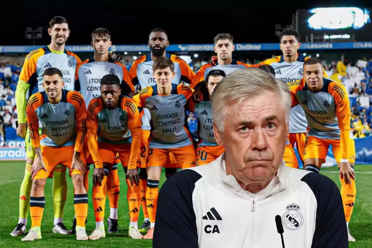 Un equipo de fútbol posando en el campo con su entrenador en primer plano.