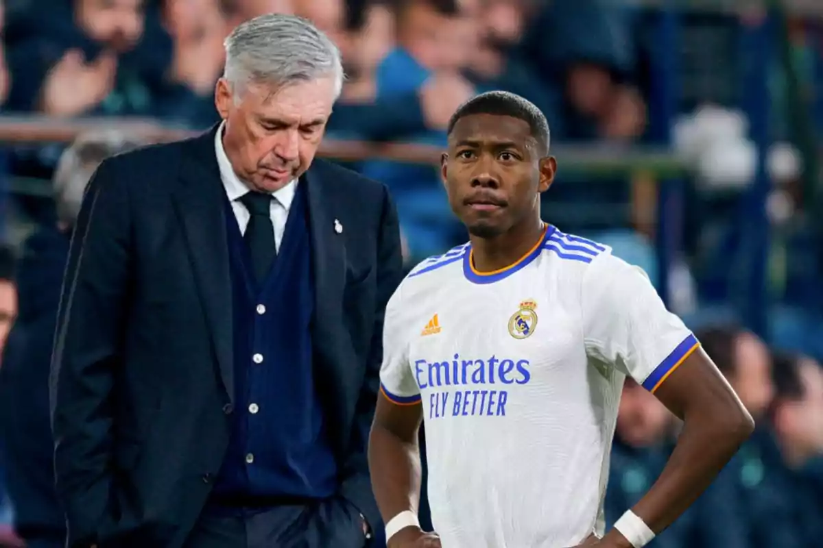 Un entrenador de fútbol y un jugador del Real Madrid en el campo durante un partido.