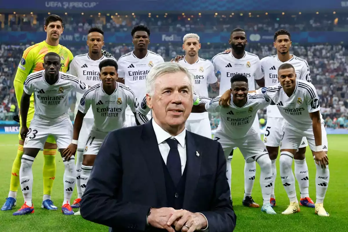 Un equipo de fútbol posando en el campo con su entrenador al frente.