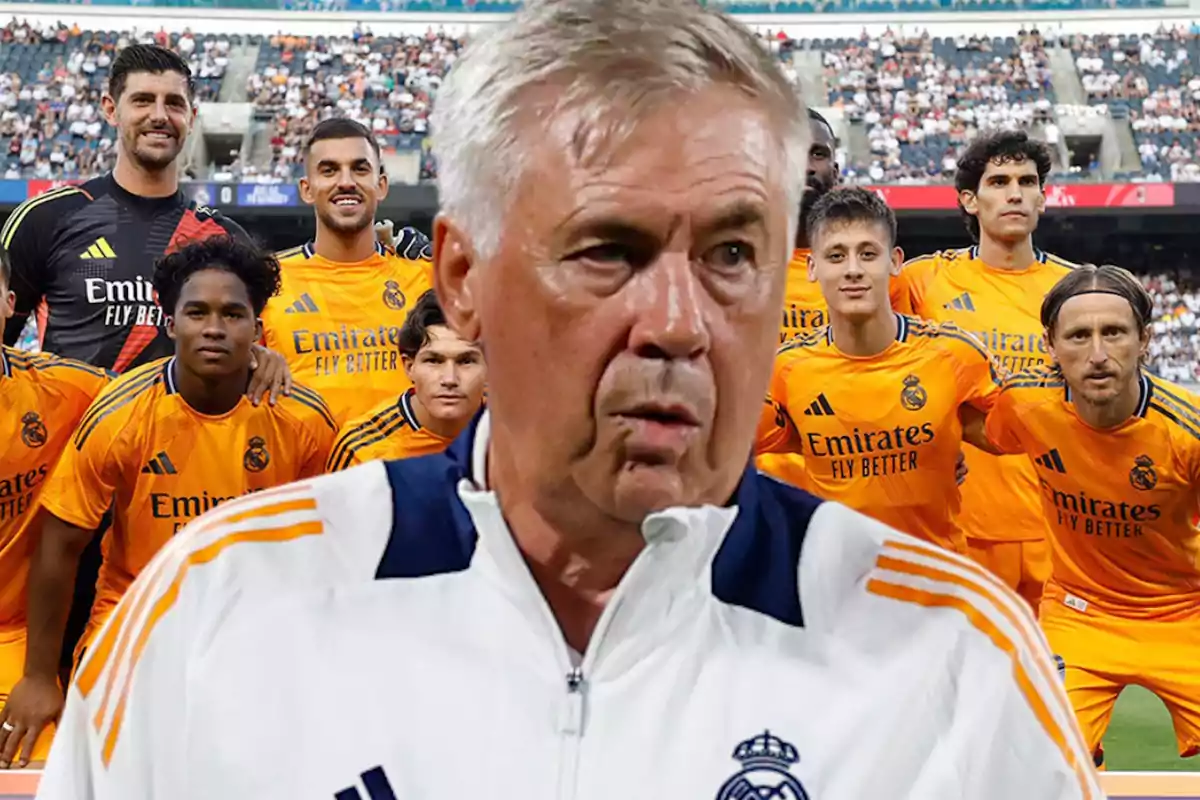 Un grupo de jugadores de fútbol con uniformes naranjas posando para una foto en un estadio, con Ancelotti en primer plano.