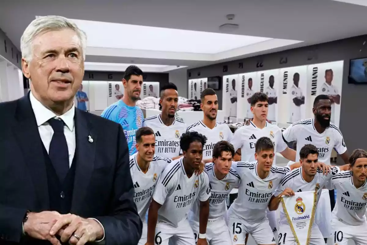 Un entrenador de fútbol y un equipo posando en un vestuario.