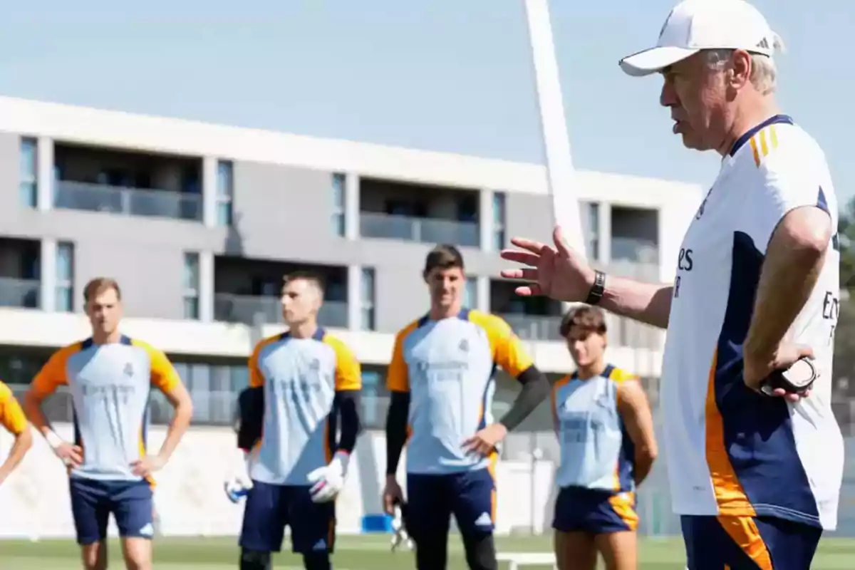 Un entrenador de fútbol da instrucciones a sus jugadores durante una sesión de entrenamiento.