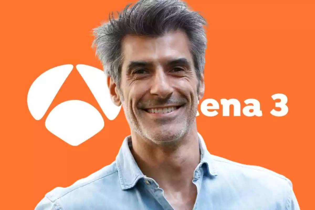 Hombre sonriendo frente a un fondo naranja con el logo de Antena 3.