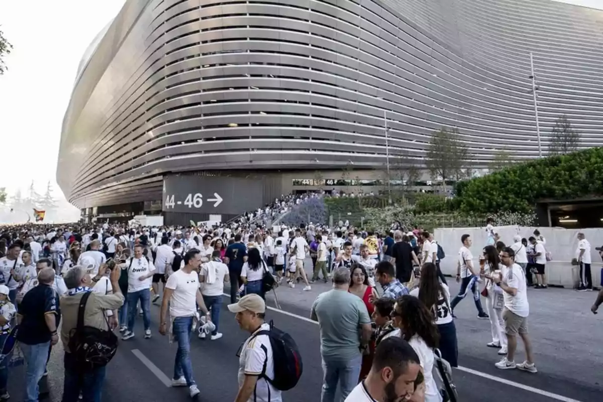 Una multitud de personas con camisetas blancas se congrega frente al nuevo Santiago Bernabéu