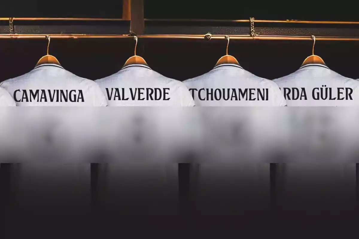 La imagen muestra cuatro camisetas de fútbol colgadas en perchas, con los nombres "CAMAVINGA", "VALVERDE", "TCHOUAMENI" y "ARDA GÜLER" impresos en la parte posterior.