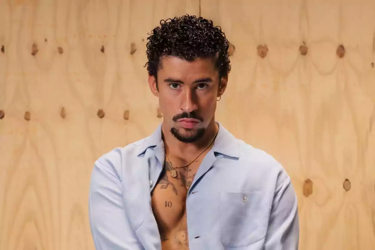 Un hombre con camisa azul clara y fondo de madera. Un hombre con camisa azul clara y fondo de madera.