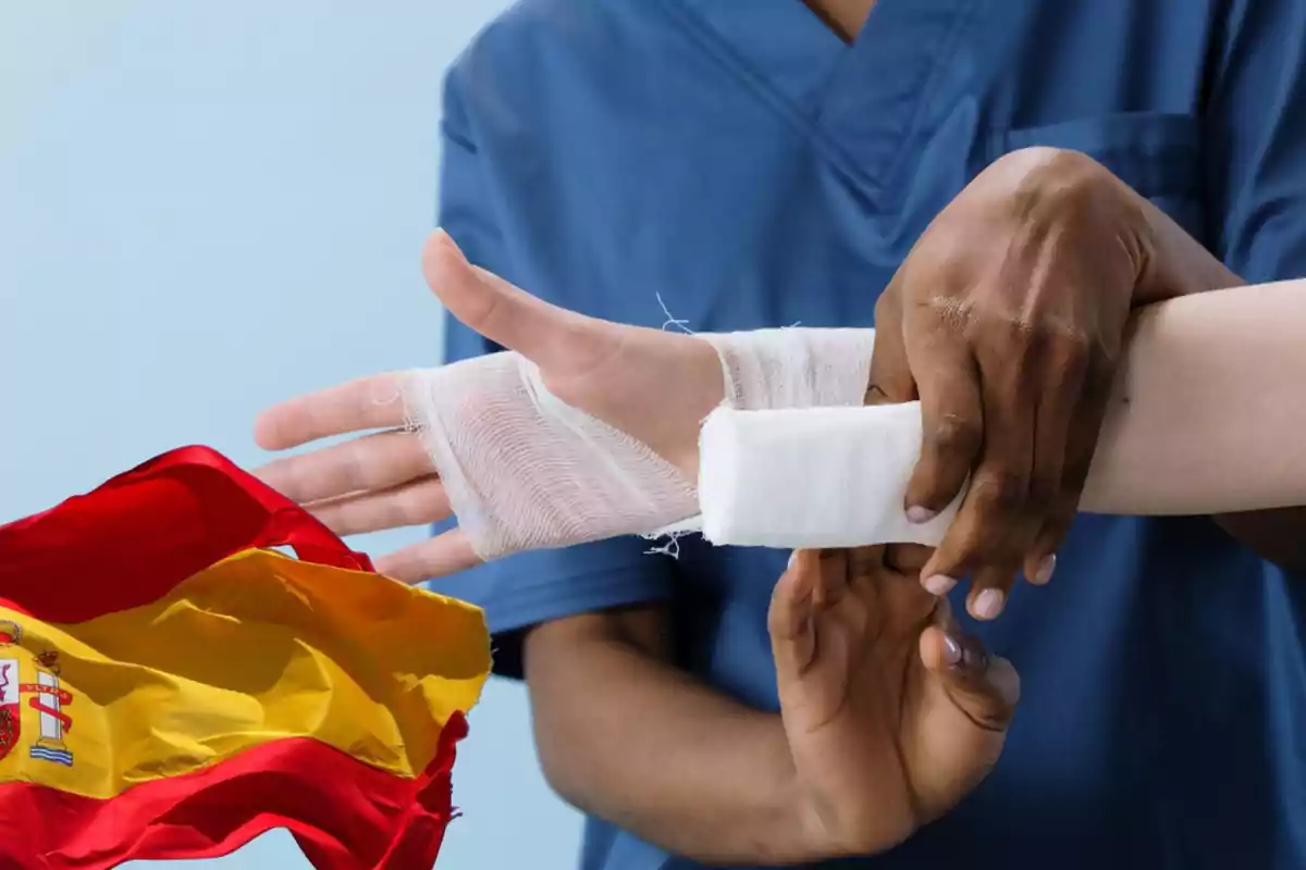 Un profesional de la salud vendando la mano de una persona con una bandera de España en primer plano.