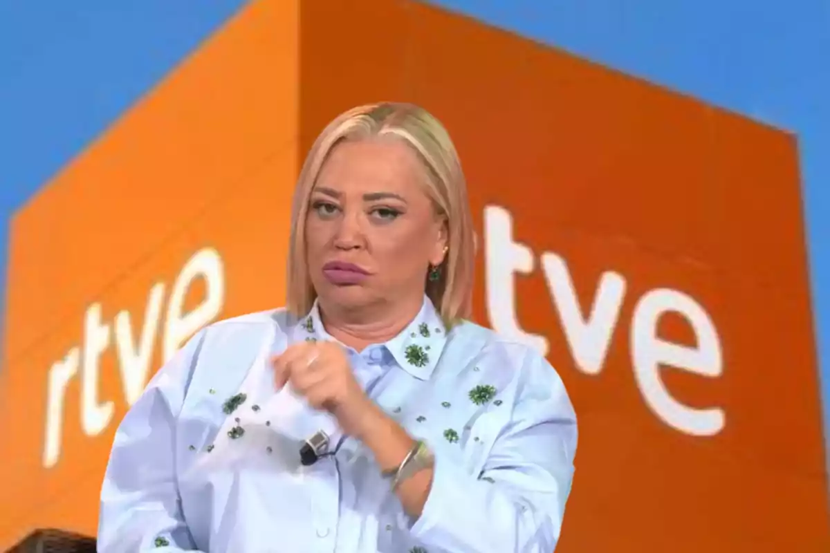 Una persona con cabello rubio y expresión seria frente a un fondo con el logo de RTVE.