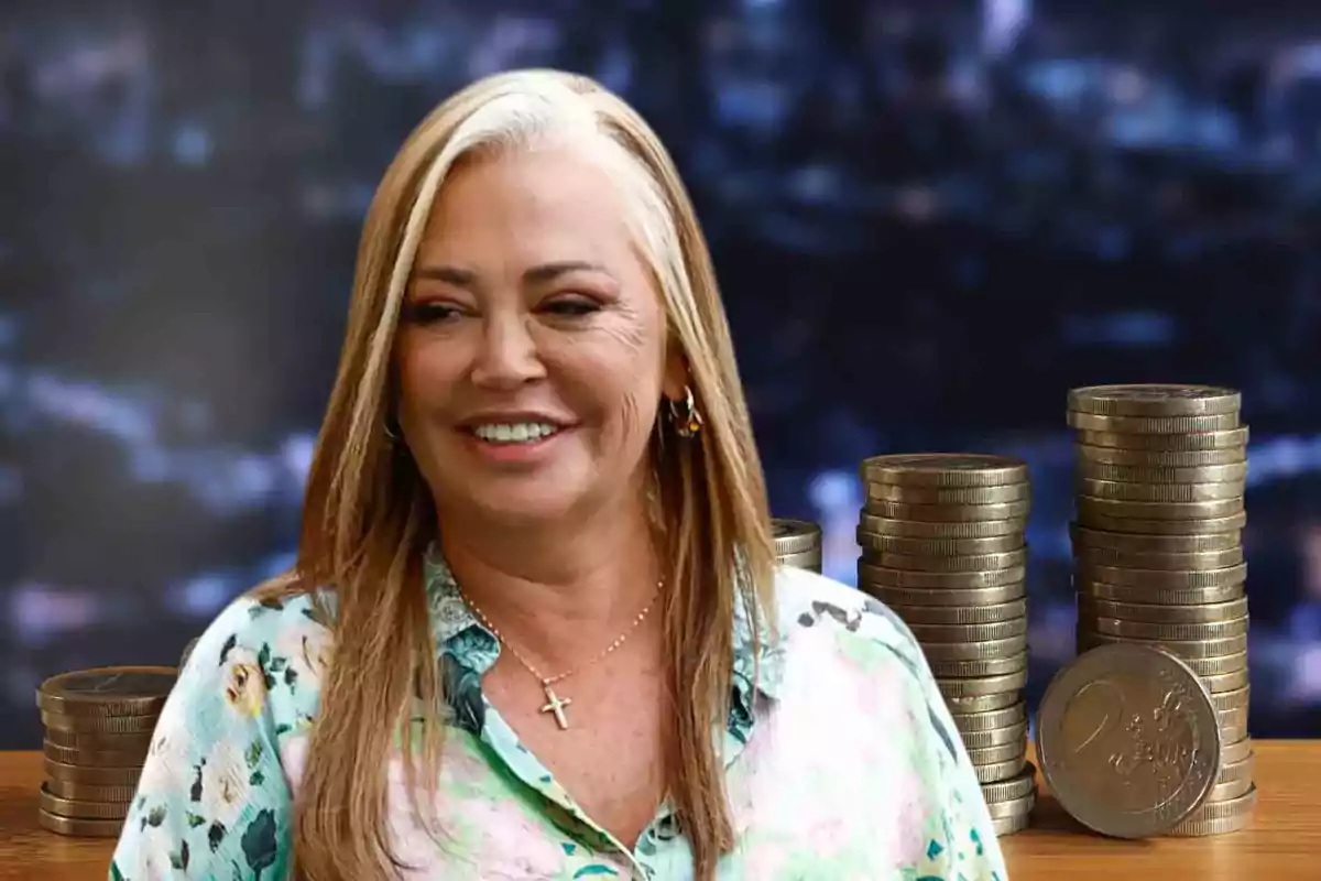 Mujer sonriendo con fondo de monedas apiladas sobre una mesa.