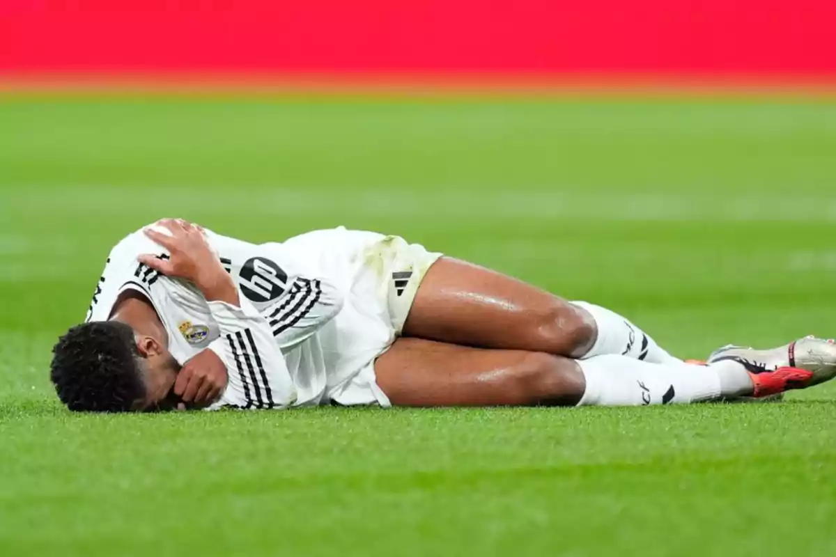 Jugador de fútbol tendido en el césped durante un partido.