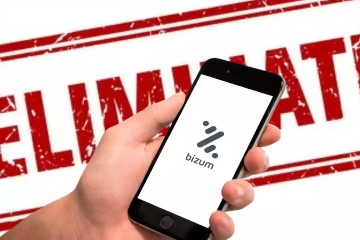 Una mano sostiene un teléfono móvil que muestra el logo de Bizum con la palabra "ELIMINATED" en el fondo.