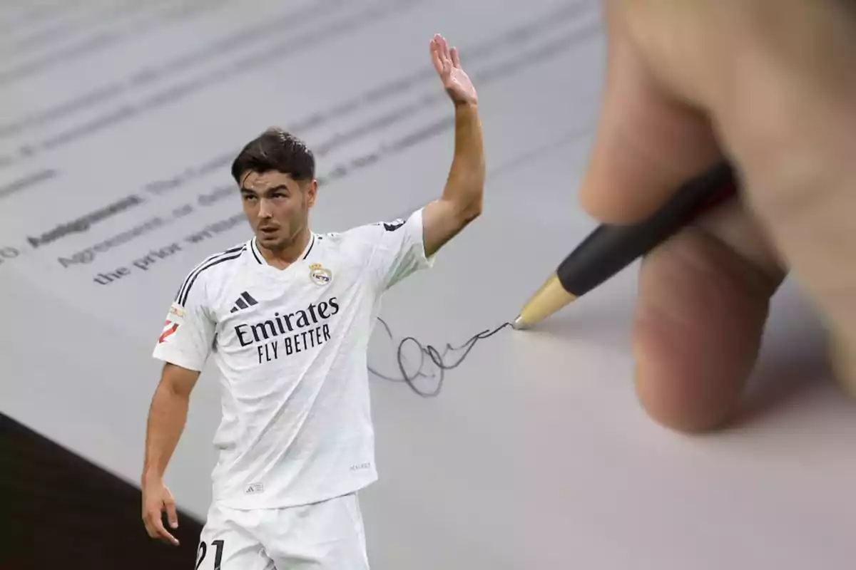 Un jugador de fútbol con el uniforme del Real Madrid aparece superpuesto sobre una imagen de una mano firmando un documento con un bolígrafo.