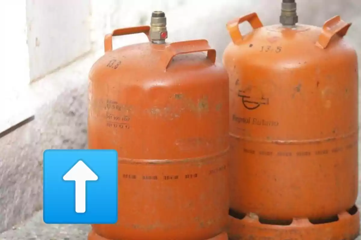 Dos bombonas de gas butano de color naranja con un icono de flecha azul hacia arriba en la parte inferior.