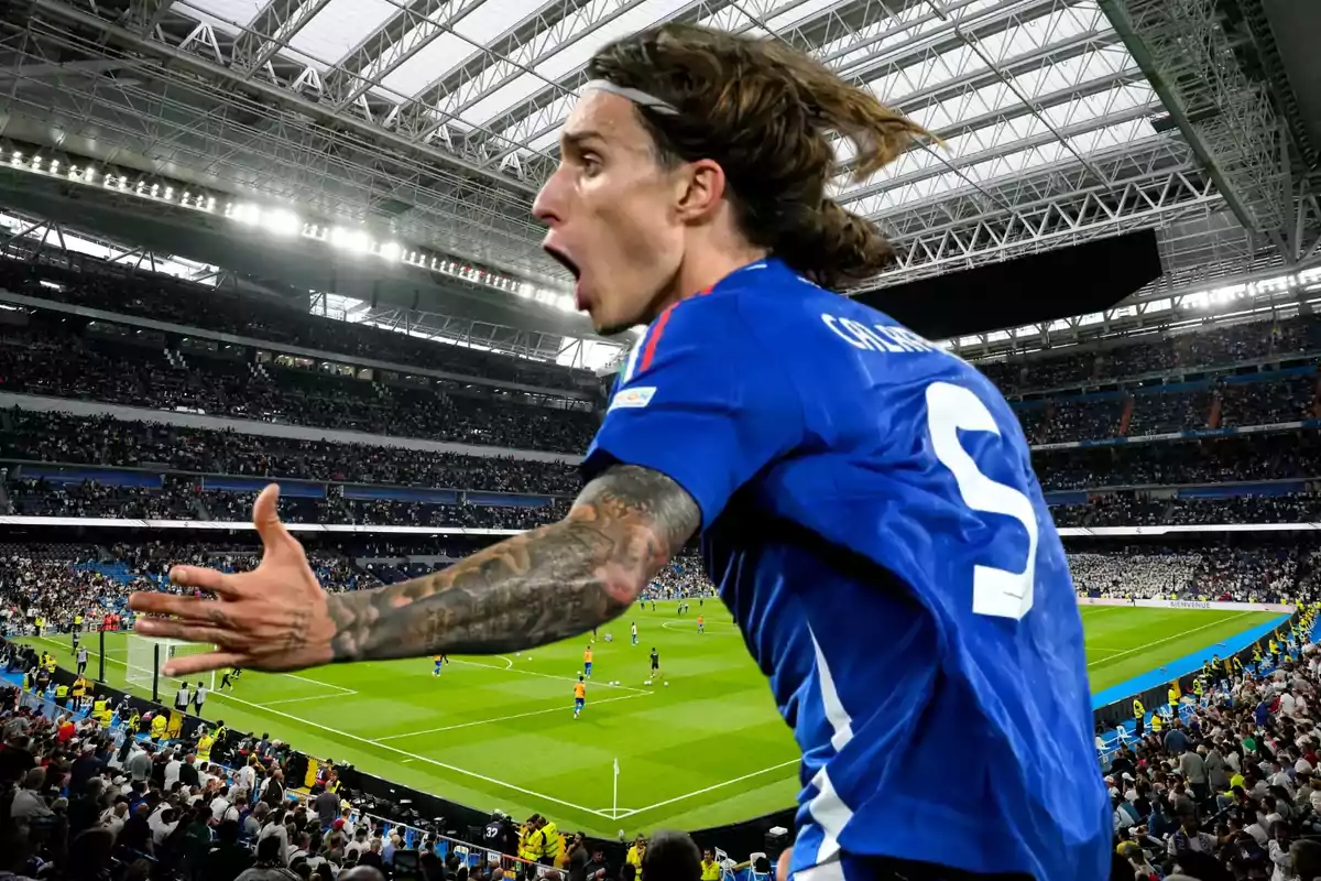 Un jugador de fútbol con camiseta azul celebra efusivamente en un estadio lleno de espectadores.