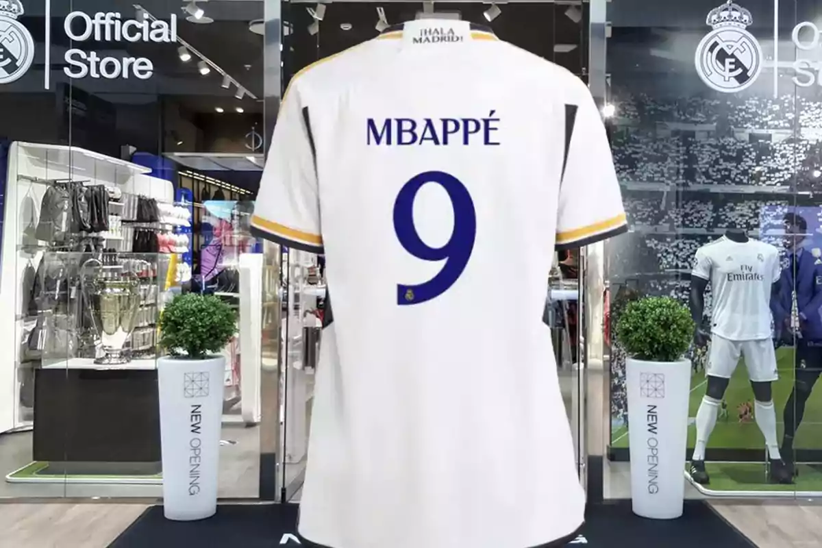 Una camiseta de fútbol blanca con el nombre "MBAPPÉ" y el número 9 en la espalda, exhibida en una tienda oficial del Real Madrid.