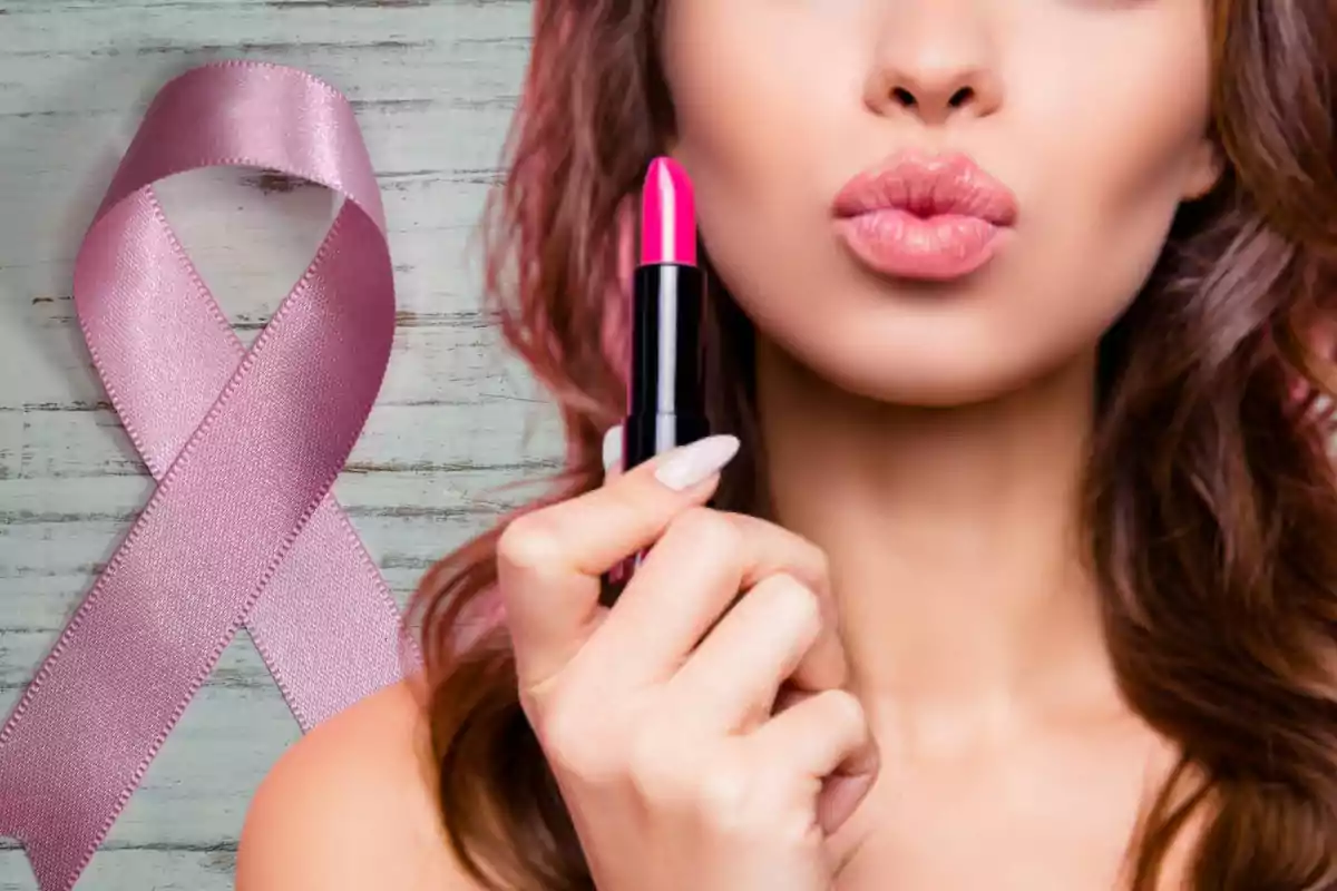 Mujer con lápiz labial rosa y lazo rosa de concienciación sobre fondo de madera.