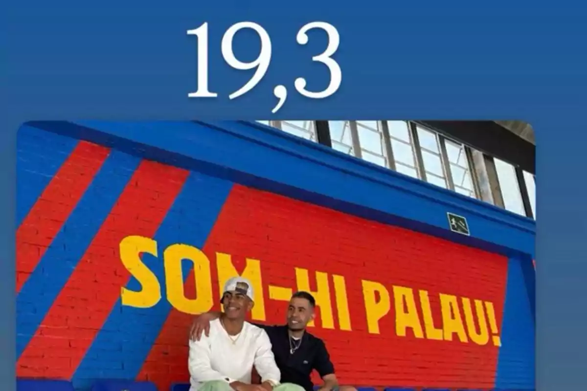 Padre e hijo sentado sobre un fondo azul y grana con letras amarillas y el número 19,3 Padre e hijo sentado sobre un fondo azul y grana con letras amarillas y el número 19,3