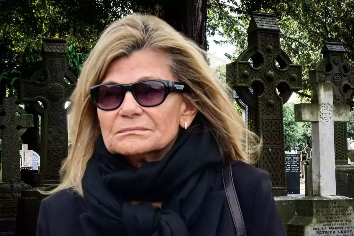 Una mujer con gafas de sol y bufanda negra en un cementerio con cruces celtas.