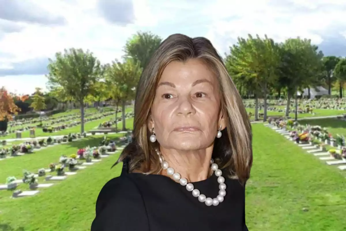 Una mujer con collar de perlas y vestido negro está en un cementerio con lápidas y árboles al fondo.