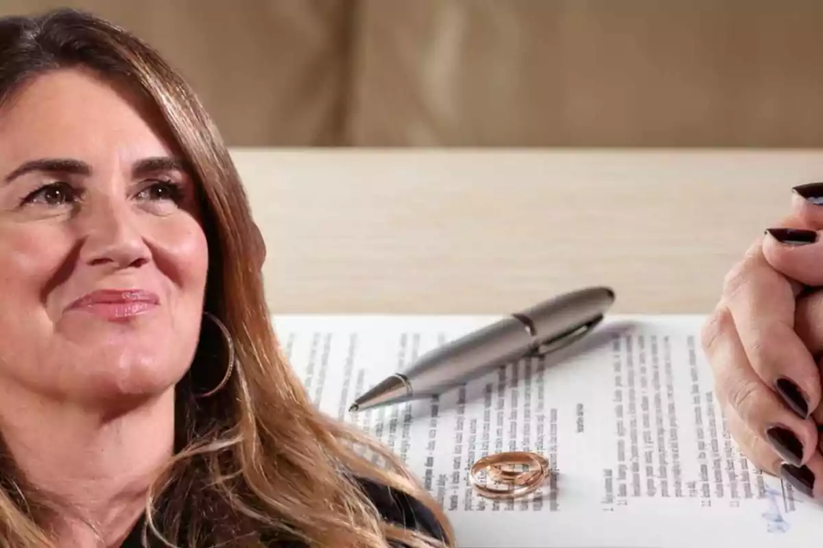 Una mujer sonriente con cabello castaño claro, junto a un documento con un bolígrafo y un par de anillos sobre la mesa.