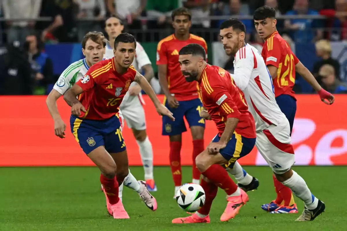 Jugadores de fútbol en acción durante un partido, vistiendo uniformes rojos y blancos, con un balón en el campo. Jugadores de fútbol en acción durante un partido, vistiendo uniformes rojos y blancos, con un balón en el campo.
