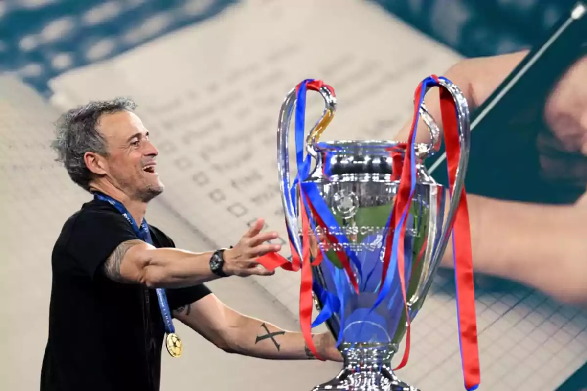 Hombre sonriente con medalla y trofeo de fútbol decorado con cintas rojas y azules sobre un fondo de libreta y mano escribiendo
