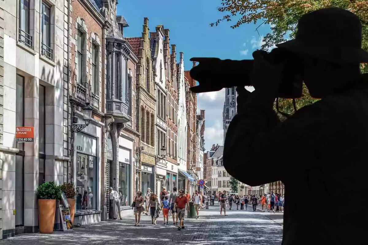 Una calle concurrida con edificios históricos y un fotógrafo en silueta capturando la escena.