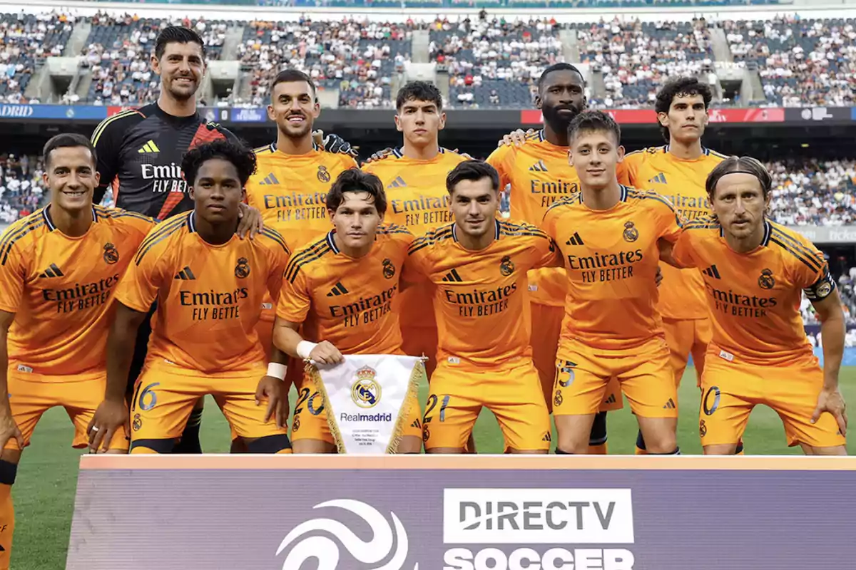 Jugadores del Real Madrid posando para una foto de equipo en el campo de fútbol.