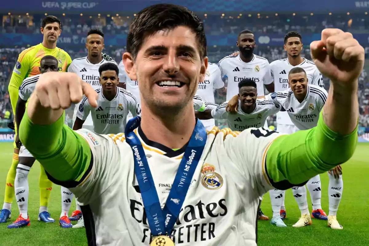 Un grupo de jugadores de fútbol del Real Madrid celebrando en el campo con uno de ellos en primer plano mostrando una medalla.