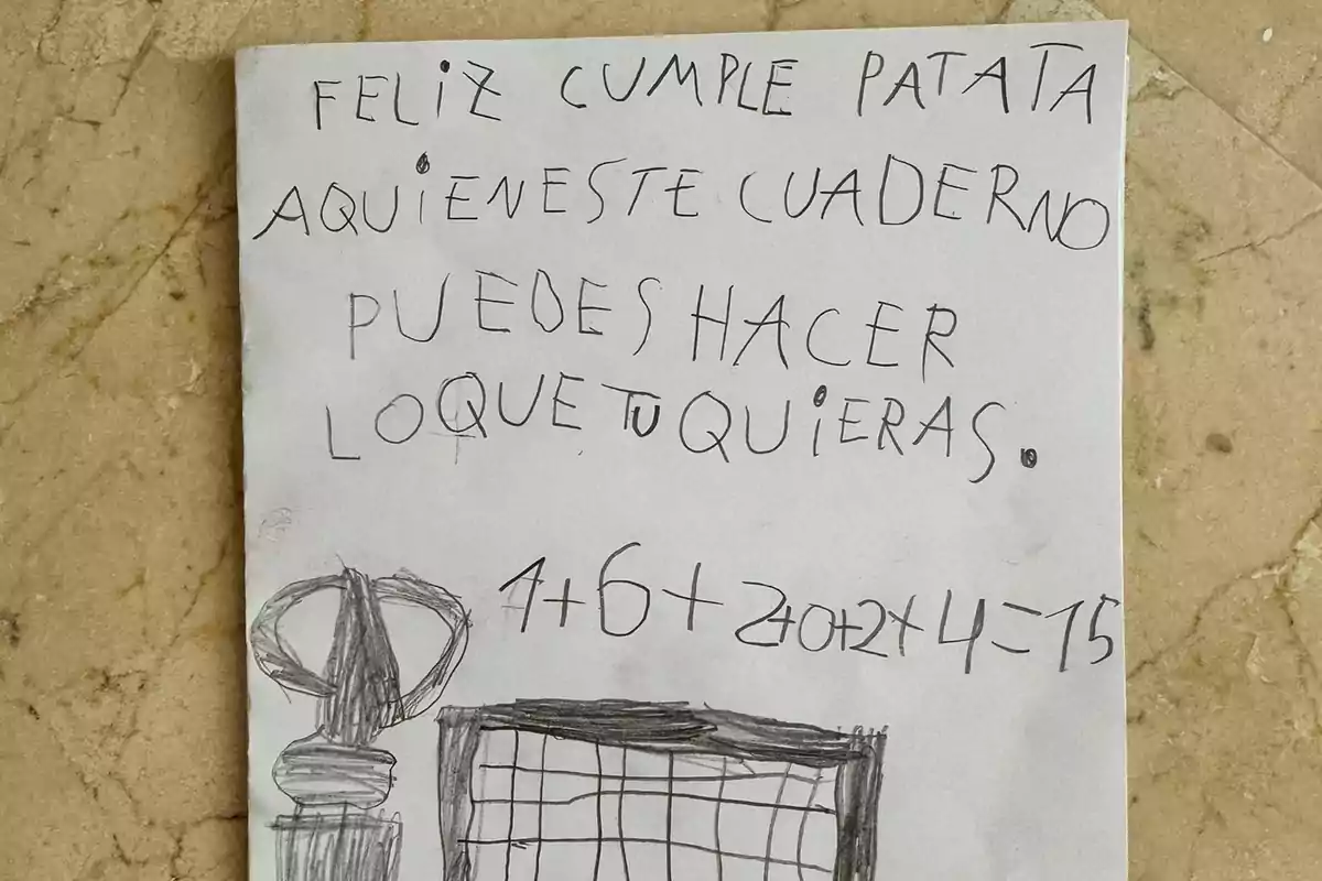 La imagen muestra una hoja de papel con un mensaje escrito a mano que dice: "Feliz cumple patata, aquí en este cuaderno puedes hacer lo que tú quieras. 4+6+2+2+1+2=15". También hay un dibujo en la parte inferior de la hoja.