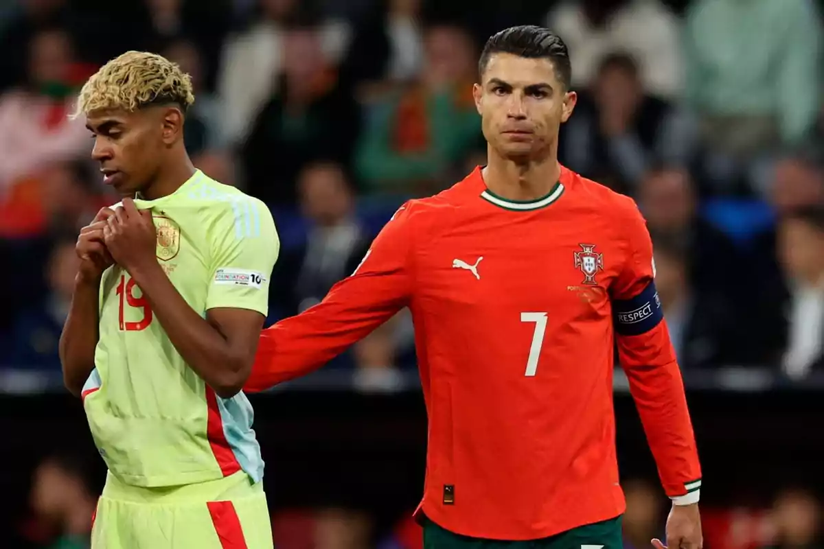 Un jugador de Portugal con el número 7 y un jugador de España con el número 19 están en el campo durante un partido de fútbol, el jugador portugués pone la mano en el hombro del español. Un jugador de Portugal con el número 7 y un jugador de España con el número 19 están en el campo durante un partido de fútbol, el jugador portugués pone la mano en el hombro del español.
