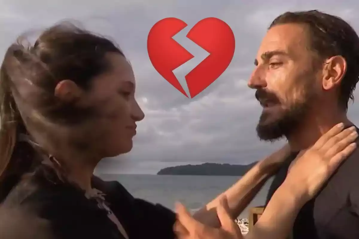 Una pareja se enfrenta en la playa con un emoji de corazón roto sobre ellos.