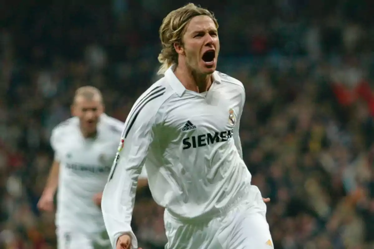 Un futbolista con uniforme blanco celebra efusivamente en el campo de juego. Un futbolista con uniforme blanco celebra efusivamente en el campo de juego.