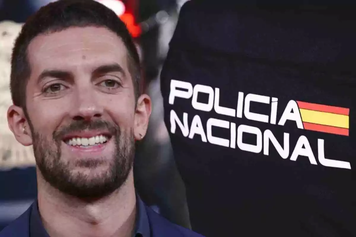 Un hombre sonriente junto a un uniforme de la Policía Nacional de España.