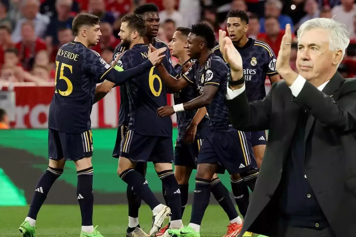 Carlo Ancelotti aplaudiendo mientras de fondo la plantilla del Real Madrid celebra un gol