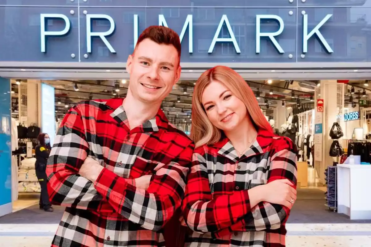 Un hombre y una mujer vestidos con el mismo pijama a cuadros rojos escoceses delante de la entrada de una tienda Primark