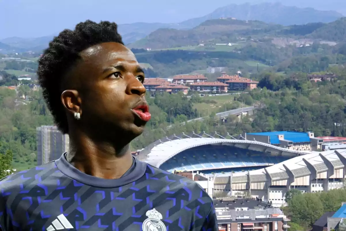 Un jugador de fútbol con la camiseta del Real Madrid aparece en primer plano, con un estadio y un paisaje montañoso de fondo.