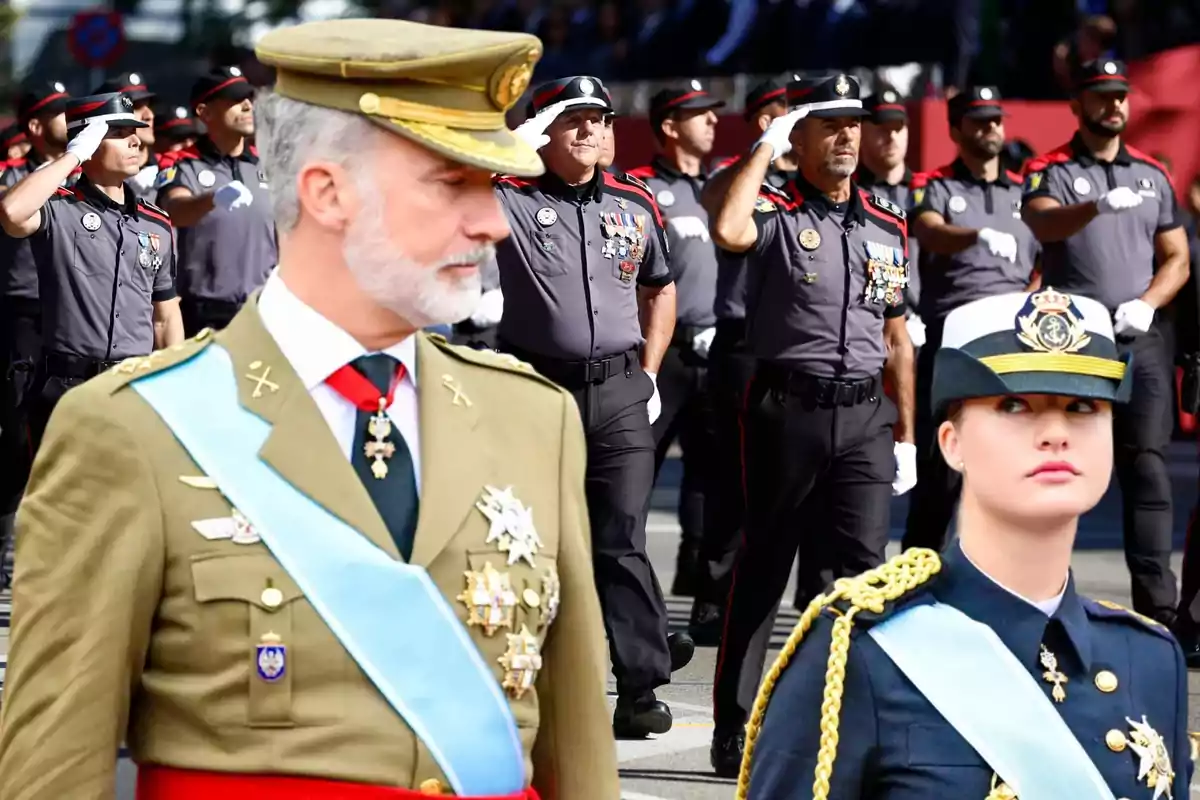 Un desfile militar con oficiales uniformados marchando y saludando.