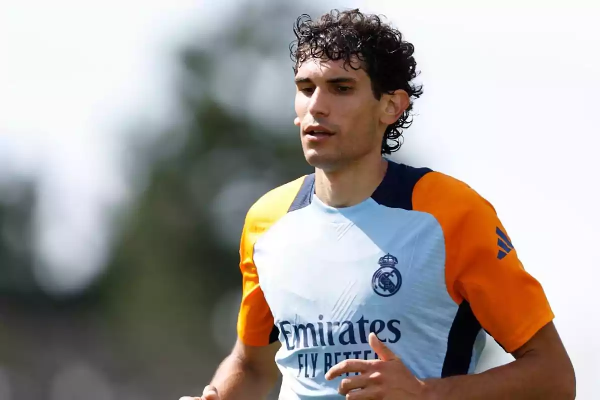 Un jugador de fútbol con una camiseta de entrenamiento del Real Madrid corre durante una sesión de práctica.