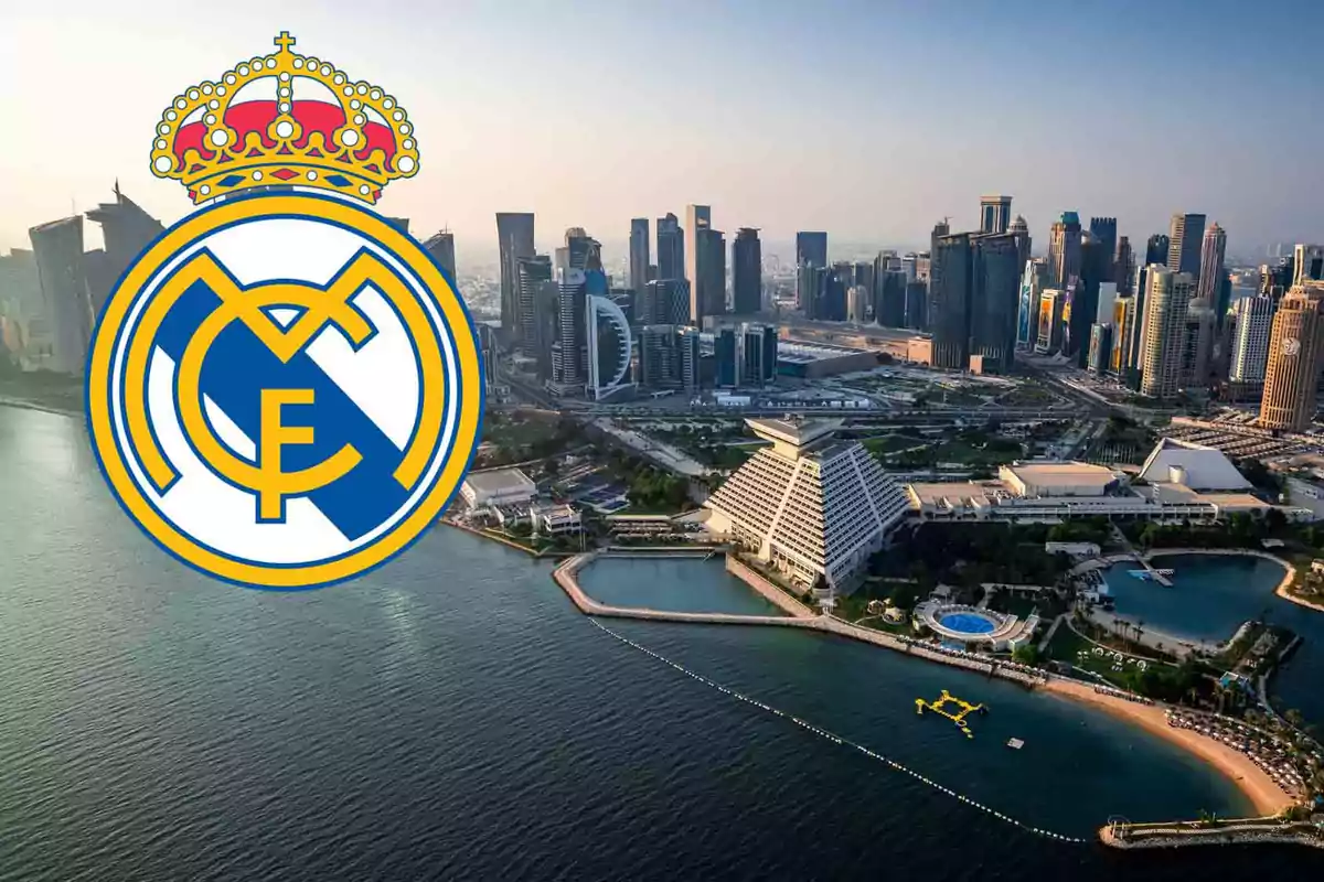 Vista aérea de una ciudad moderna junto al mar con el escudo del Real Madrid superpuesto.